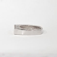 a white gold wedding ring with diamond accents on the outside, set in 18k white gold