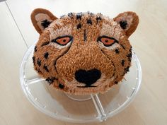 a cake shaped like a cheetah on top of a plastic container