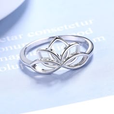 The Sterling Silver Lotus Flower Ring is a beautiful piece of jewelry that symbolizes purity, enlightenment, and rebirth. The lotus flower has a deep spiritual meaning in many cultures and religions, and this ring is a stunning representation of that symbolism. The ring features a detailed lotus flower design that is expertly crafted from high-quality sterling silver. The intricate details of the lotus petals and the central stamen create a sense of depth and dimension, giving the ring a unique Elegant Silver Flower Ring Hallmarked, Silver Flower-shaped Rings For Gift, Lotus Ring Silver, Lotus Inspired Jewellery, Sterling Silver Lotus Flower Jewelry For Gifts, Lotus Flower Ring, Lotus Ring, Lotus Flower Design, Coffee And Espresso Maker