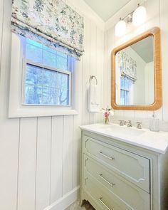 a bathroom with a sink, mirror and window in it's center wall is painted white