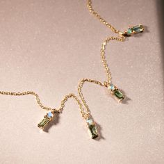 A stone and gold chain necklace lies flat on a shimmering background. It has opals and tourmalines conjoined by gold. Pearl And Diamond Earrings, Green Sea, Tennis Bracelet Diamond, Engagement Jewelry, Engagement Ring Wedding Band, Diamond Bracelets, Delicate Necklace, Wedding Ring Bands, Chain Bracelet