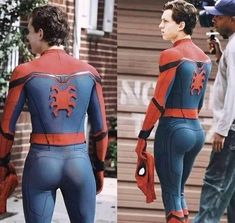 a man in a spiderman suit is walking down the street with his hands on his hips