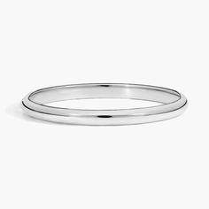 a plain wedding ring with a thin band in white gold, on a gray background