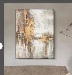 an abstract painting hangs on the wall above a couch in a room with white walls