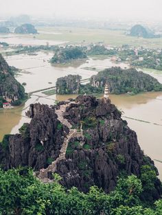 an aerial view of some rocks and water in the middle of a mountain range with trees on both sides