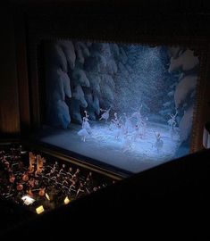 a group of ballet dancers on stage in front of a large screen with lights behind them