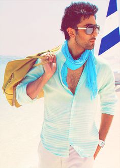 a man wearing sunglasses and a scarf on the beach