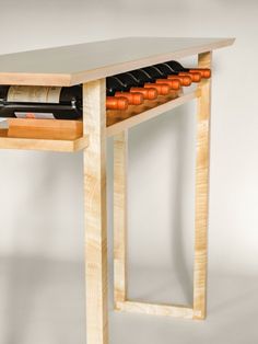 a wooden table with two wine bottles on it and an open drawer underneath the table