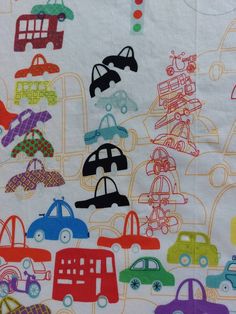 a white fabric with colorful cars on it