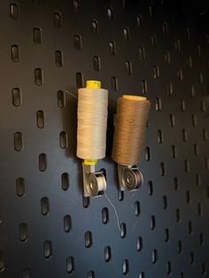 two spools of thread are hanging on the wall