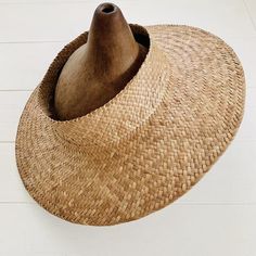 a large hat with a wooden stick sticking out of it's center hole on the floor