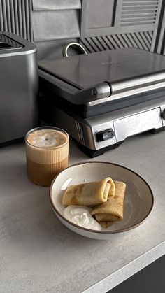 a plate with some food on it next to a toaster and cup of coffee