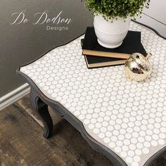 a table with a potted plant on top of it next to some books and a pair of scissors