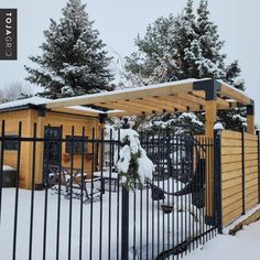 a fence with snow on the ground and trees in the background