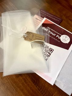 a wooden table topped with envelopes and a small comb in plastic bag on top of it