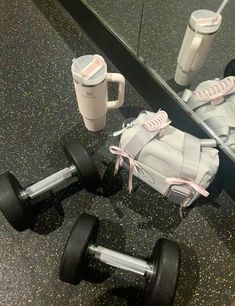 a pair of shoes and a coffee cup are on the floor in front of a mirror