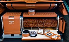 an orange vehicle with its trunk open and other items in the back seat, including a coffee maker