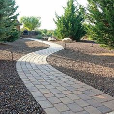 a brick path in the middle of a graveled area