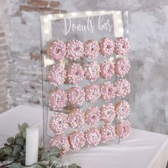 a table topped with donuts covered in pink frosting