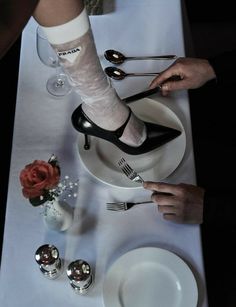 two people with their feet on a plate and one is holding a knife and fork