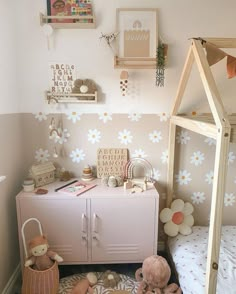 a child's room with pink furniture and flowers on the wall, including a crib