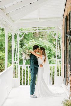 a bride and groom kissing on the porch