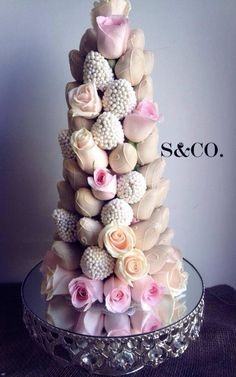 a wedding cake with pink and white flowers on it's tiered display stand