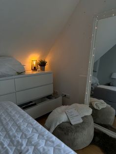 a bedroom with a bed, dresser and mirror in the corner next to each other