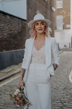 Bride wears white fedora wedding hat and bridal suit complete with lace top whilst standing in the street on wedding day Winter Wedding Trends, Wedding Suits For Bride, Winter Wedding Dresses, Winter Wedding Accessories, Winter Wedding Fashion, Bridal Coat, Bride Suit, Winter Wedding Outfits, Women Suits Wedding