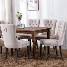 a dining room table and chairs with beige upholstered fabric on the backrests