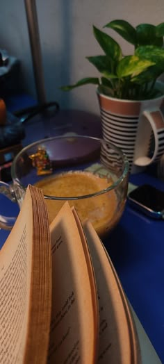 an open book sitting on top of a table next to a bowl filled with food