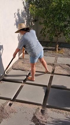 a little boy that is standing on some concrete blocks with a stick in his hand