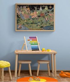 a child's table and chair in front of a painting on the wall