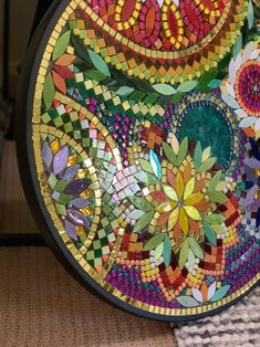 a colorful plate sitting on top of a table covered in lots of different colored tiles