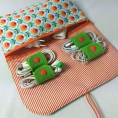 an orange and white striped bag with two small green cars on it's side