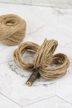 two twine rope on top of a marble floor next to a piece of wood