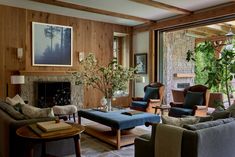 a living room filled with furniture and a fire place in front of a large window