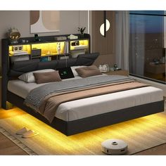 a large bed sitting next to a window with yellow lights on the headboard and foot board