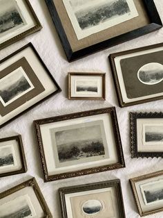 many framed pictures are arranged on a white tablecloth with black and white trimmings