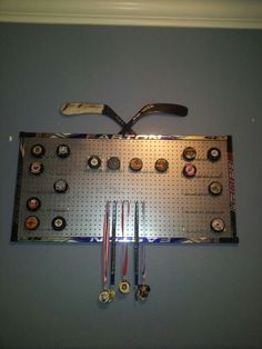 there is a metal pegboard with several different items on it and two wrenches hanging from the wall