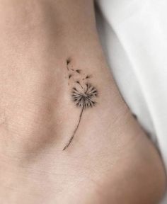 a small dandelion tattoo on the side of a woman's stomach is shown