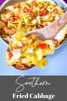 a pan filled with fried cabbage and bacon next to a wooden spoon on top of a blue table