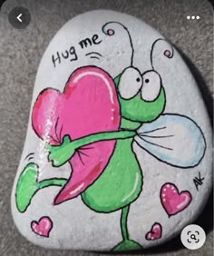 a painted rock with a cartoon character holding a heart