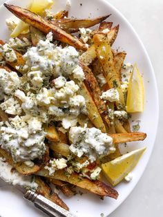 a white plate topped with potato wedges covered in blue cheese