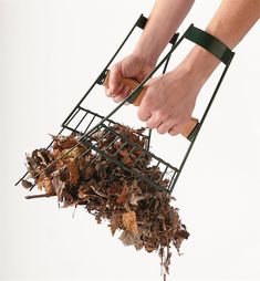 a person is picking up leaves from a pile with their hands and feet on top of them