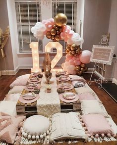 a table set up with balloons, plates and cake for a 21st birthday party at home