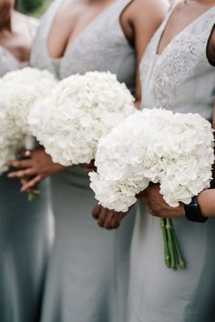 the bridesmaids are holding bouquets of white hydrangeas in their hands