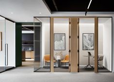 an office with glass walls and wooden doors