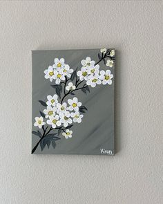 a painting of white flowers on a gray background with the word vegan written below it