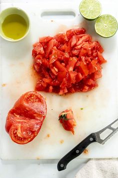 chopped tomatoes and limes on a cutting board